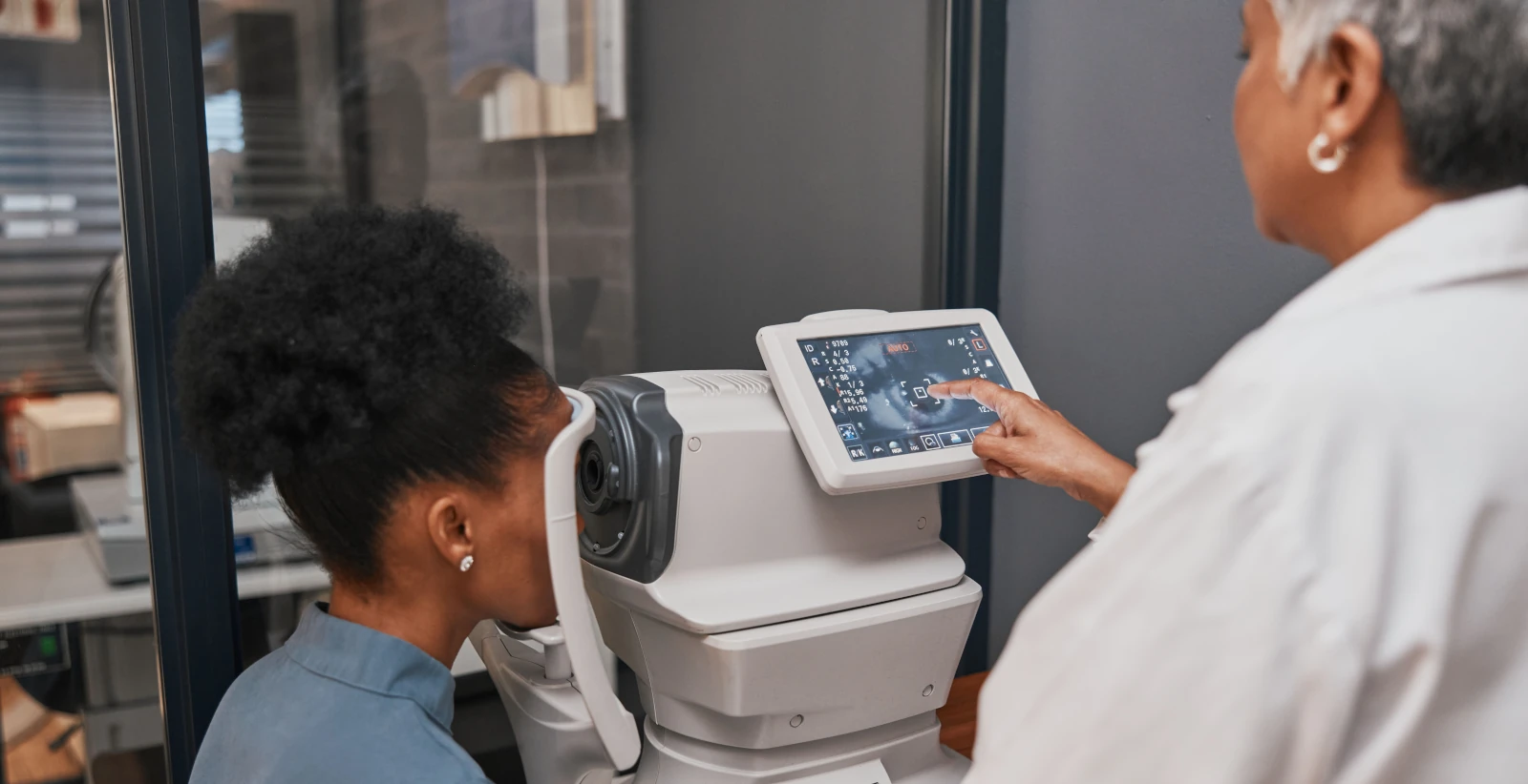 Optometrist using modern diagnostic equipment during an eye exam